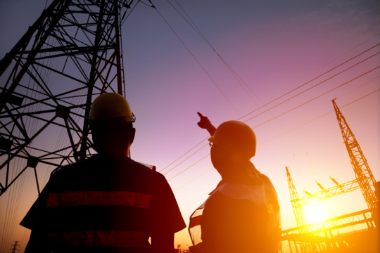 Two worker watching the power tower and substation 467305852 5616x3744